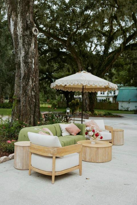 A lounge setting under the oaks with a scalloped umbrella