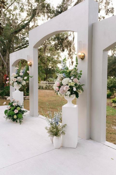 White ceremony arches with pastel florals