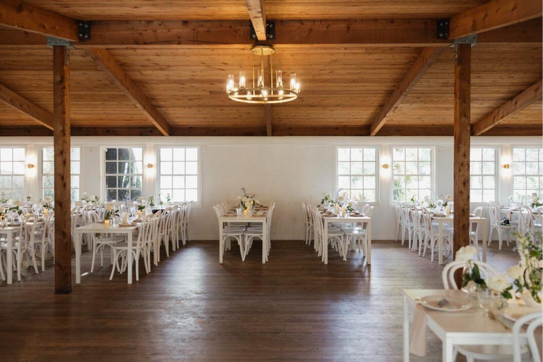 The indoor reception hall with timber beams and a chandelier