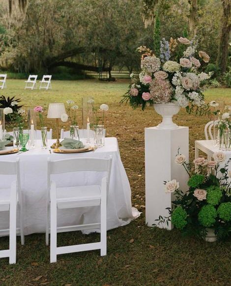 A reception table dressed in white linen with pastel florals