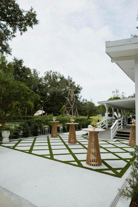 The courtyard with timber cocktail tables and the farmhouse porch